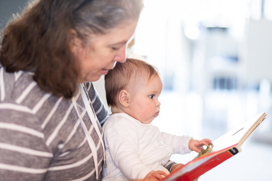 Grandmother reading book with baby grandchild