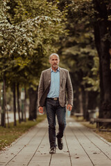 Focused businessman in a suit walking in the park