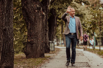 Fototapeta premium Focused businessman in a suit walking in the park