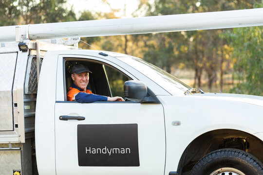 Happy man driving his ute working for himself as handyman in country