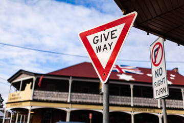 Give way street sign at intersection of side road with main street in Aussie town