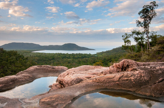 Pools in granite above Zoe Falls with views of Hinchinbrook Island in the background