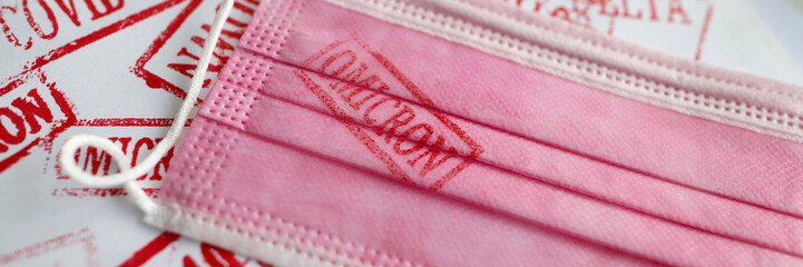 Pink medical mask with omicron print closeup