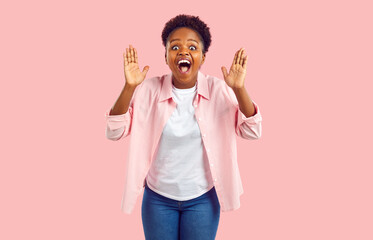 Overjoyed attractive African American woman screams with wonder or joy experiences WoW emotions and...