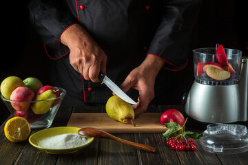 The chef prepares fruit jam from fresh apples and pears in an electric blender. Menu or recipe idea for hotel or restaurant