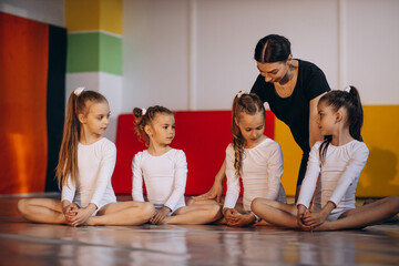 Girls practising aerobics with teacher at gymnastic school