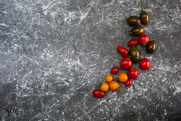 Tomatoes on a black and white background yellow red brown burgundy tomatoes healthy food fresh vegetables bright food vegan background for a menu site in a restaurant top view flat lay