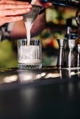 man hand bartender making cocktail in glass on the bar counter