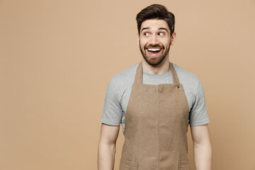 Young smiling happy surprised man barista barman employee wear brown apron work in coffee shop...