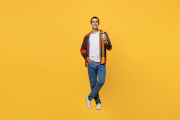 Fototapeta na wymiar Full body young middle eastern man 20s he wear casual shirt white t-shirt hold takeaway delivery craft paper brown cup coffee to go isolated on plain yellow background studio People lifestyle concept.