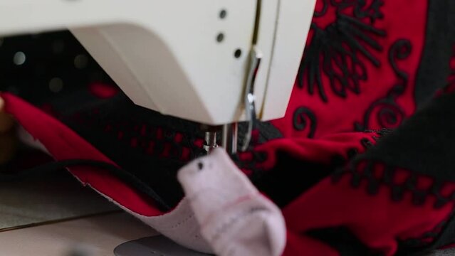 Woman tailor sewing on electric machine a jacket