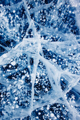 Fototapeta na wymiar Gas methane bubbles frozen in winter ice of lake Baikal. Top view abstract background