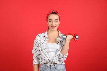 Woman with dumbbell as symbol of girl power on red background. 8 March concept