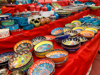 Fototapeta na wymiar Authentic hand made Turkish ceramic bowls with vibrant bright colours and intricate hand painted design at local market. Sourced from Turkey. Can be used as home decor or for serving. Iznik pottery.