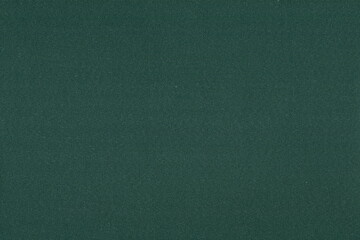 The texture of a coarse, dense dark green heavy fabric. Background of coarse natural fabric.