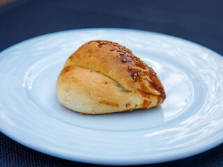 Traditional turkish bun pastry product , tasty pogaca with cheese filling on white plate close up