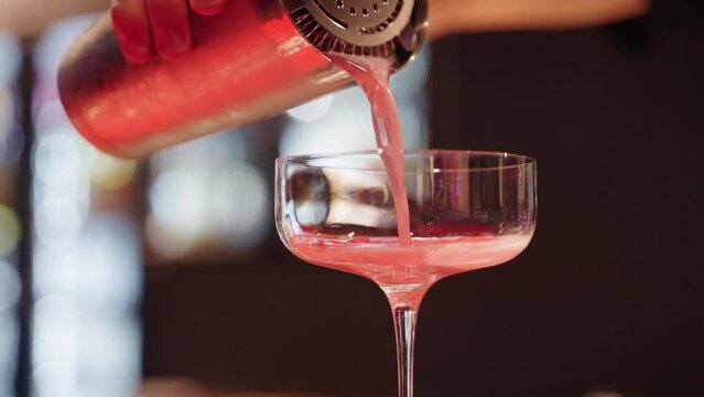 Close Up Bartender Pouring Cocktail From Steel Shaker Into Margarita Glass, 4K Slow Motion
