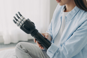 Application of bionic hands. Disabled woman customizing sensory robotic prosthetic arm, close up