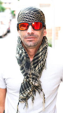 Hombre Joven con pa&ntilde;uelo en la cabeza y gafas, pa&ntilde;uelo tipo  &aacute;rabe, shemag, pirata, o bandolero, sonriendo a c&aacute;mara.