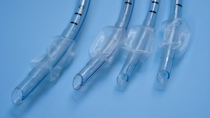 endotracheal tubes of different sizes and diameters lie on a light blue background