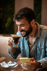 Freelance men drinking coffee and using mobile