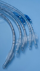 endotracheal tubes of different sizes and diameters lie on a light blue background