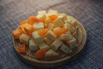 Cheese tasting on a wooden plate. Food for wine and romantic, cheesy delicacies. Cheese set.