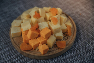 Cheese tasting on a wooden plate. Food for wine and romantic, cheesy delicacies. Cheese set.