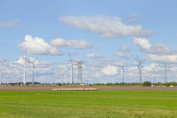 Wind turbines and electricity pylons in Wustermark with dynamic sky, federal state of Brandenburg...