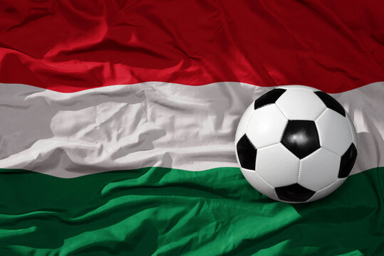 vintage football ball on the waveing national flag of hungary background. 3D illustration
