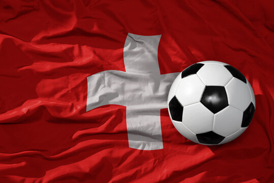 vintage football ball on the waveing national flag of switzerland background. 3D illustration