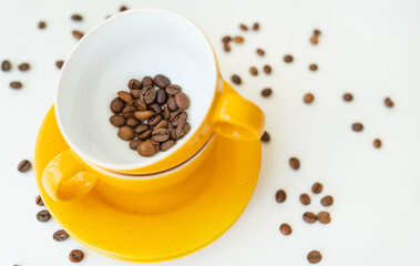 Beautiful morning, the process of making coffee, a yellow cup on a white table, scattered coffee beans.
