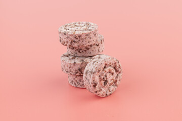 Heap of medicine colored pills, tablets on a pink background
