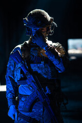 Army soldier in Combat Uniforms with an assault rifle and combat helmet night mission dark...
