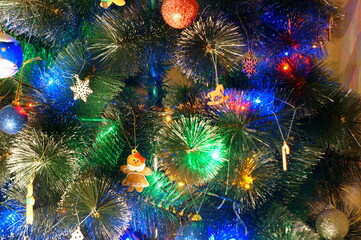 Obraz na płótnie Canvas Christmas tree decorated with toys and glowing garlands.