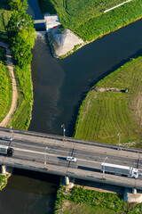 Aerial view of a bridge over a river with several cars in the morning on a summer day