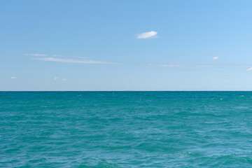 View of the calm sea at noon, clear sunny weather, idea for a background or screen saver.