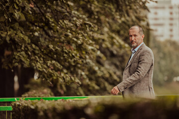 Fototapeta premium Focused businessman in a suit walking in the park