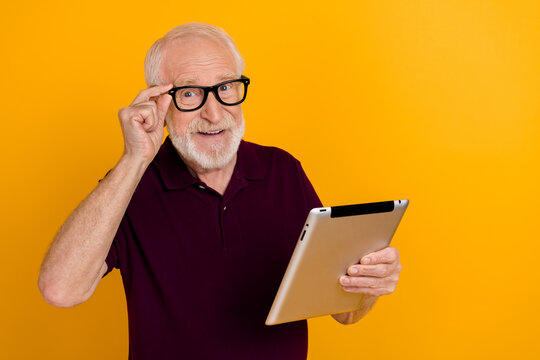 Photo of mature man use tablet clever button subscribe download app isolated over yellow color background - Powered by Adobe
