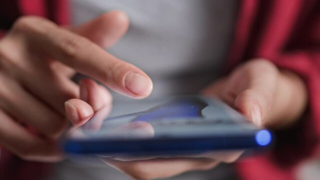 Online shopping via phone placing an order through the site's shopping cart buying clothes in an online store, female fingers clicking on the phone screen choosing clothes for her wardrobe
