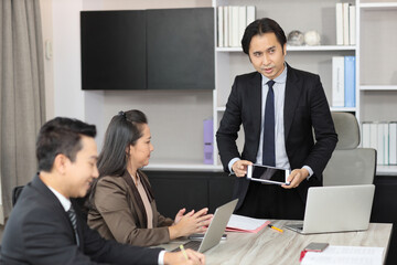Collaborative process of professional businesspeople going over on new project together, using tablet presentation and brainstorming ideas, coworker and working together at office meeting concept