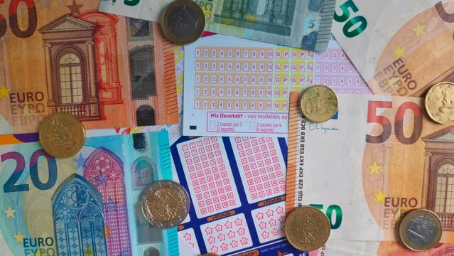 Rotating stack of various French grid of loto and gambling games with euro banknotes and coins on them