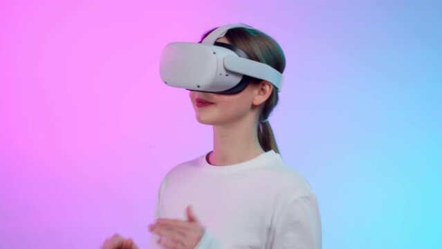 Young woman in vr headset dancing isolated over colorful background