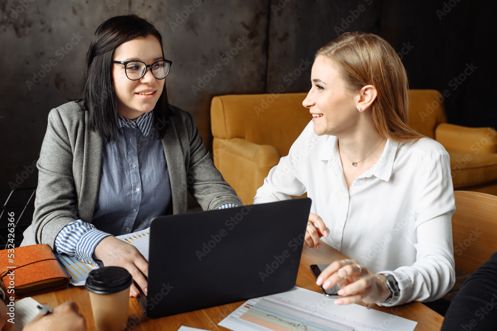 Wall mural teamwork. close-up portrait of two women in smart casual clothes in office with laptop. they are smi