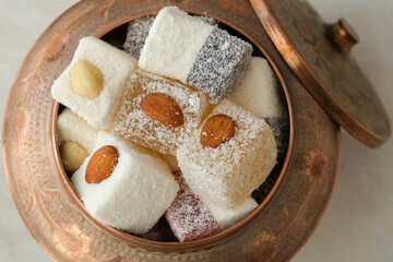 Turkish delight in copper bowl on white background.Close up top view.