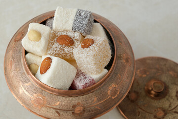 Turkish delight in copper bowl on white background.Close up top view
