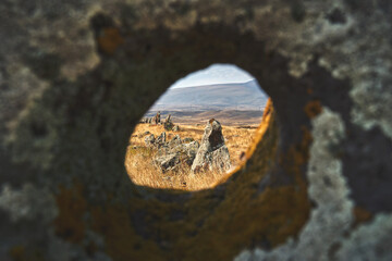 View through the hole in a stone at Carahunge prehistoric archaeological site in Armenia