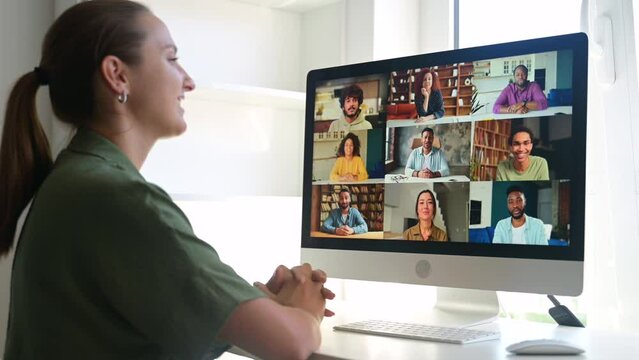 Side view female entrepreneur using computer app for video call sitting in home office, young woman involved in video conference, watching educational classes at home