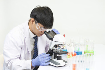 young attractive asian scientist working in chemical laboratory,doing chemistry experiments with...