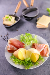 plate of potato, salami and salad with raclette cheese